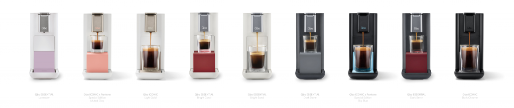 Reihe von Qbo Kaffeemaschinen in verschiedenen Farben, einschließlich lila, rosa, grau und schwarz.